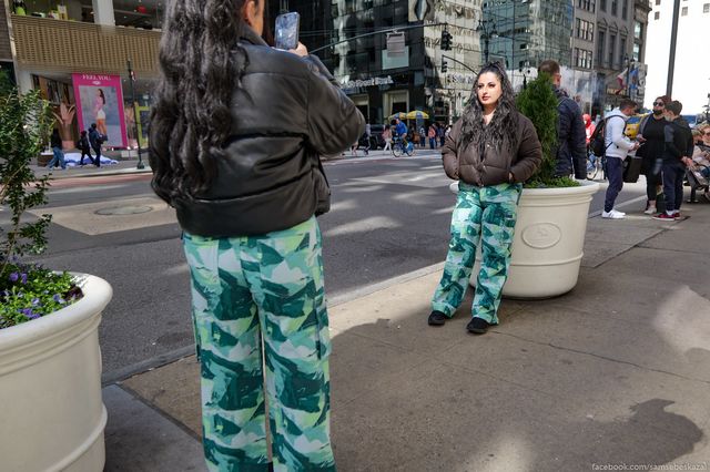 tourists in matching outfits take pictures of each other in Midtown
